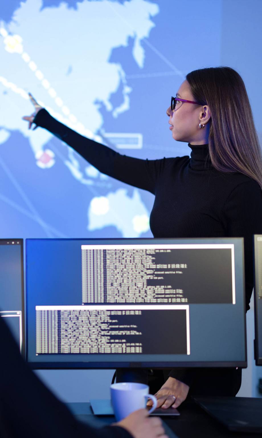 Professional cyber security team working to prevent security threats, find vulnerability and solve incidents. Woman pointing on a event map. SSUCv3H4sIAAAAAAAACnRSy46cMBC8R8o/IJ9jyRgMeK97jpRDblEObbsZrPVgBPZGq9X8ewweRt48bnR1U1Vd7vfPn6qKKNisJk/V+16l2joXt7BCsH5OMPtyx1ecDa4l8ro2HSsBsGWFxga/WnAlqCDoaYYrJnCOzu3w7WiSLUCIG26FFzBe4Ra8fklgfXLo5M9fx7DwhLYnuk0xBFwf0wWzhoCXZOUD97n3j1xXZyNLQEgt8h2TWe/85Y3cZbJUVHv32V+XuEuSs5f1/kP2Df3i8F9EX+2m0TmY0ceCLH/8fKR7wVm/7Rvcit1WdAg5tfsmRBpj6nbsKZMtpy2YngIfGTVGGdnXchS9Om0QDp3EjjE6YKNoW/OBSiZqKgYOTdPUqgF+WMo+yMuvtPH1CPLuAKKxvgj21Wtw+0BT2AS7wAof/ltWq+18KRAfpuPCTibt4xzWfWVSC/mw7LxfQKUon6oxKeGJT7Bt6Q9z4uUFxP1kCqnZhyMzklmJSSdy6DSNEL0YhlpK0QyS8/tAvs7JJp7D0ekxLs6DwV308eZ/3G1fp1QF6+Xj6f861jzC6y5PlA98zFhTJmd3NTJKYcZWaYojZ7Q13UhV1ynacdFLxgwimPRyt98AAAD//wMAOsgizOcDAAA=